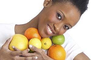 Young Woman Holding Citrus Fruit In Studio