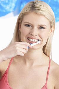 Young Woman Brushing Teeth In Studio