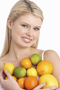 Young Woman Holding Citrus Fruit In Studio