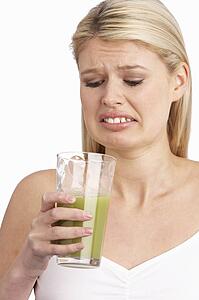 Young Woman Not Enjoying Healthy Drink In Studio