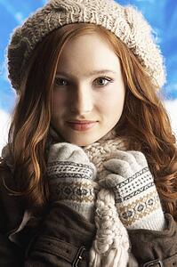 Teenage Girl Wearing Warm Winter Clothes And Hat In Studio