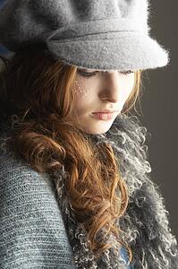 Fashionable Teenage Girl Wearing Cap And Knitwear In Studio