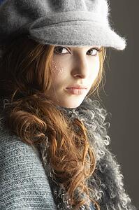 Fashionable Teenage Girl Wearing Cap And Knitwear In Studio