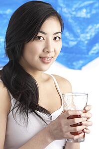 Young Woman Enjoying Healthy Drink In Studio