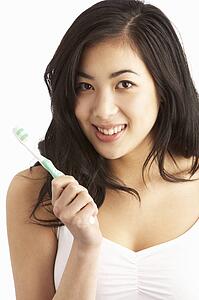 Young Woman Brushing Teeth In Studio
