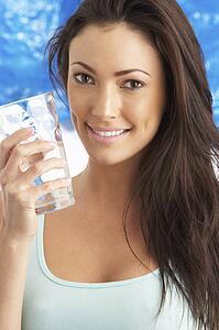 Young Woman Drinking Glass Of Water In Studio
