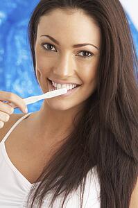 Young Woman Brushing Teeth In Studio