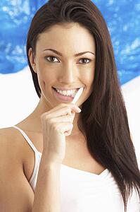 Young Woman Brushing Teeth In Studio