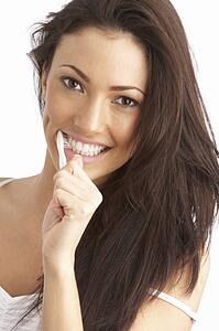 Young Woman Brushing Teeth In Studio