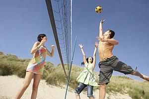 Group Of Teenage Friends Playing Volleyball On Beach