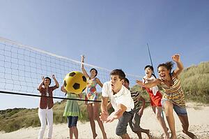 Group Of Teenage Friends Playing Volleyball On Beach