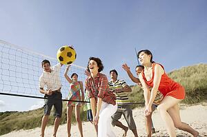 Group Of Teenage Friends Playing Volleyball On Beach