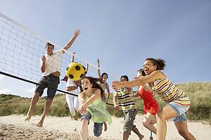 Group Of Teenage Friends Playing Volleyball On Beach