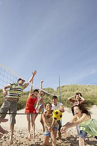 Group Of Teenage Friends Playing Volleyball On Beach