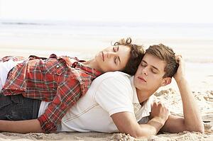 Romantic Young Couple Relaxing On Beach