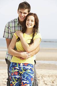 Romantic Teenage Couple Embracing On Beach 