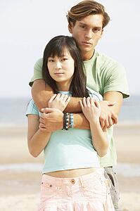Romantic Young Couple Embracing On Beach 