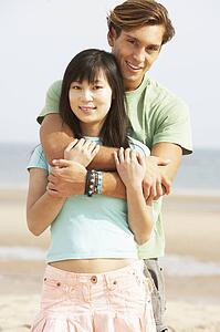 Romantic Young Couple Embracing On Beach 