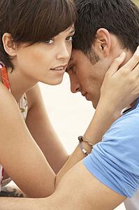 Romantic Young Couple Embracing On Beach 