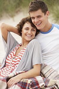 Romantic Young Couple Embracing On Beach 