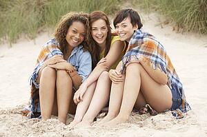 Group Of Girls Sitting On Beach Together
