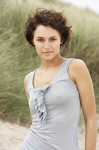 Attractive Young Woman Kneeling Amongst Sand Dunes