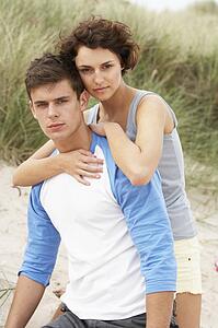 Romantic Young Couple Embracing On Beach 