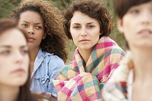 Close Up Of Group Of Girls Sitting On Beach Together
