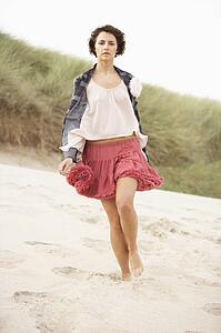 Fashionably Dressed Attractive Young Woman Standing Amongst Sand Dunes