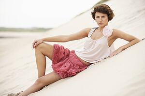 Fashionably Dressed Attractive Young Woman Standing Amongst Sand Dunes