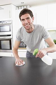 Young Man Cleaning Modern Kitchen 