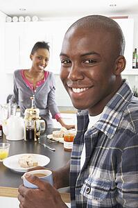 Young Couple Preparing Breakfast In Modern Kitchen 