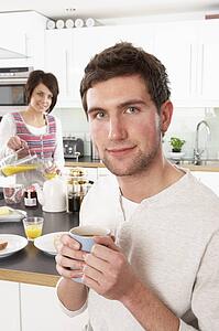 Young Couple Preparing Breakfast In Modern Kitchen 