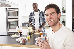 Two Young Men Preparing Breakfast In Modern Kitchen