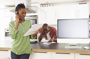 Young Couple Discussing Personal Finances In Modern Kitchen 