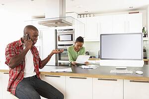 Young Couple Discussing Personal Finances In Modern Kitchen 