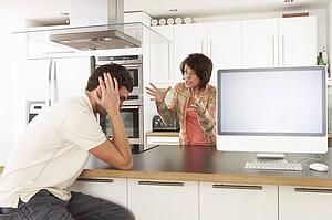 Young Couple Discussing Personal Finances In Modern Kitchen 