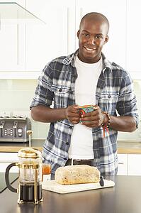 Young Man Preparing Breakfast In Modern Kitchen 