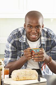 Young Man Preparing Breakfast In Modern Kitchen 