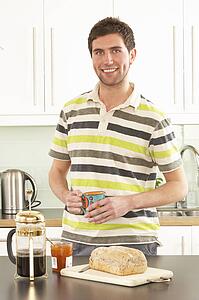 Young Man Preparing Breakfast In Modern Kitchen 
