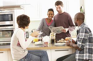 Group Of Young Friends Preparing Breakfast In Modern Kitchen