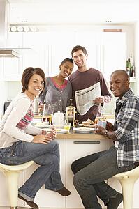 Group Of Young Friends Preparing Breakfast In Modern Kitchen