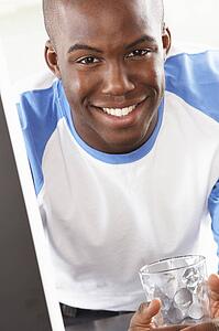 Young Man Using Computer In Modern Kitchen 