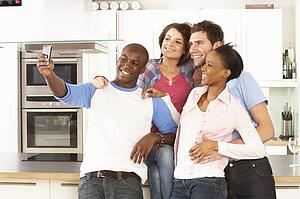 Group Of Young Friends Taking Photo In Modern Kitchen