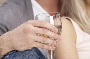 Close Up Of Hand Holding Glass Of White Wine