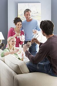 Group Of Friends Enjoying Chinese Takeaway Meal At Home