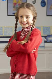 Portrait Of Female Primary School Pupil Standing In Classroom