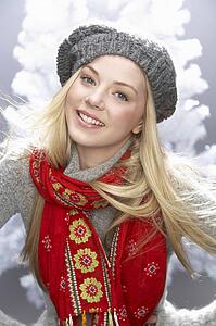 Fashionable Teenage Girl Wearing Cap And Knitwear In Studio In Front Of Christmas Tree