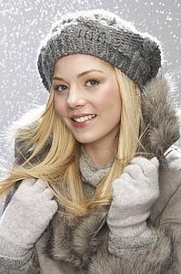 Fashionable Teenage Girl Wearing Cap And Fur Coat In Studio With Snow
