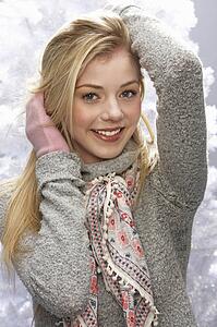 Fashionable Teenage Girl Wearing Cap And Knitwear In Studio In Front Of Christmas Tree